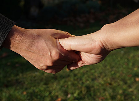 Von links kommende Hand hält von rechts kommende Hand